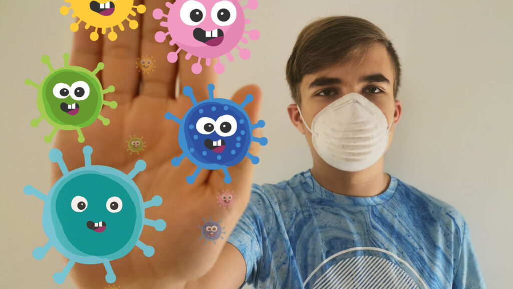 Junge mit Maske wehrt Coronaviren ab