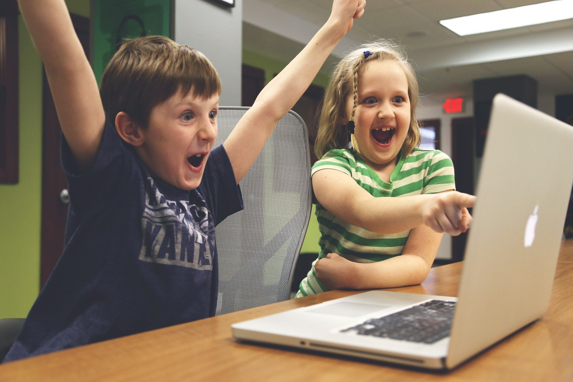 Kinder freuen sich vor einem Laptop