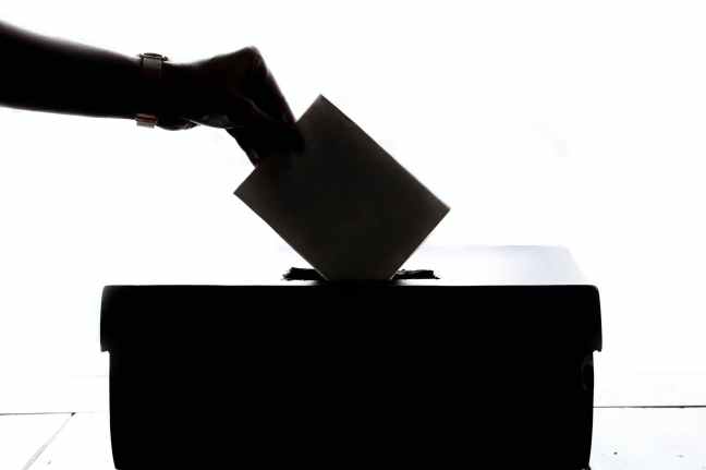 Umschlag wird in Wahlurne abgeworfen